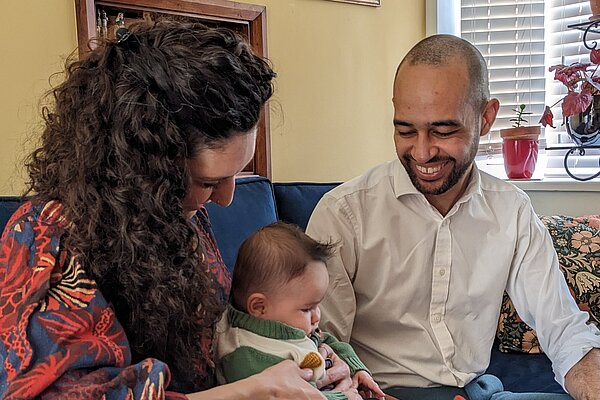 Josh speaking with a mother and baby